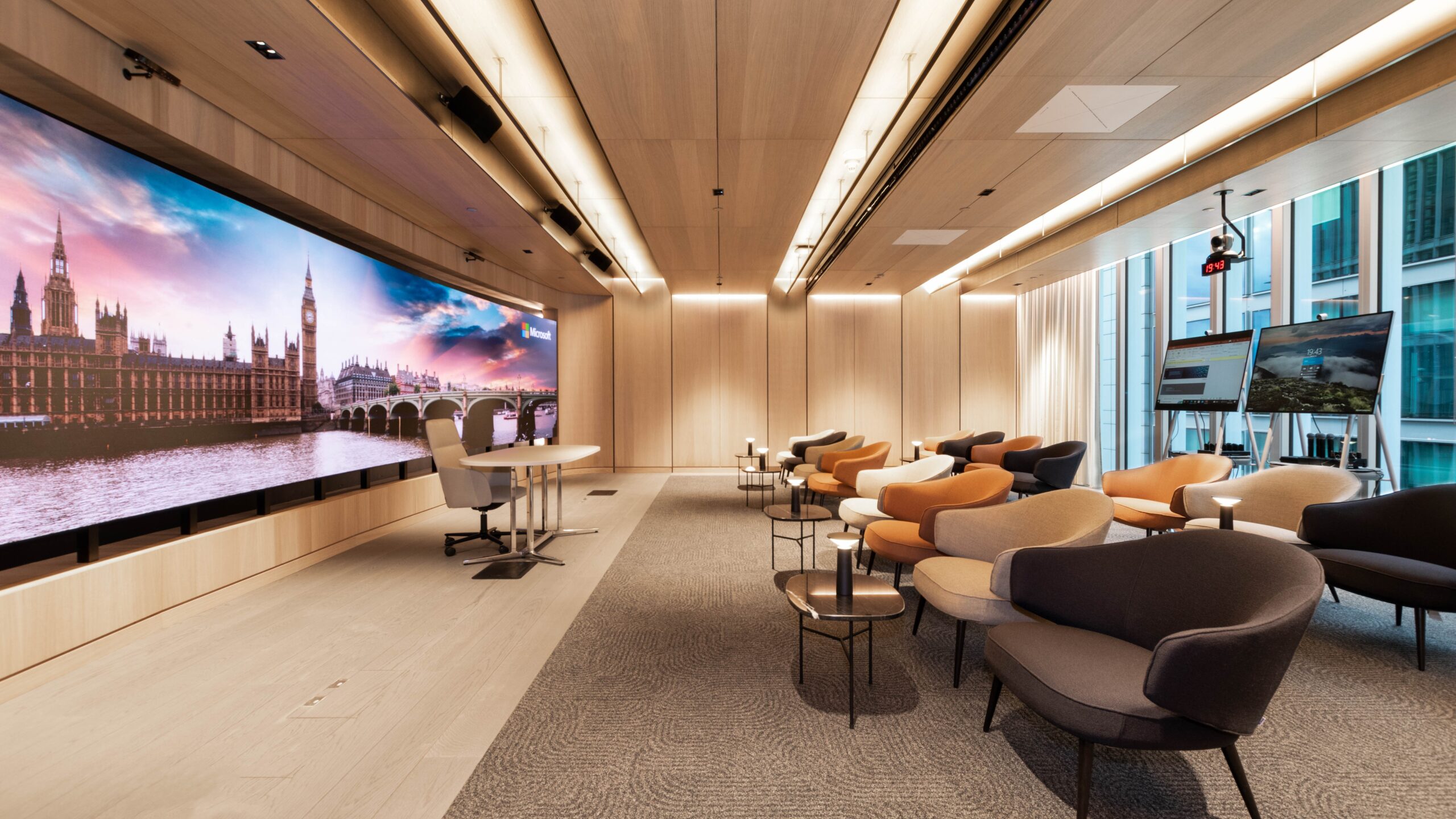 A room with chairs and a large screen spanning from wall to wall